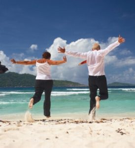 older active adults running on the beach